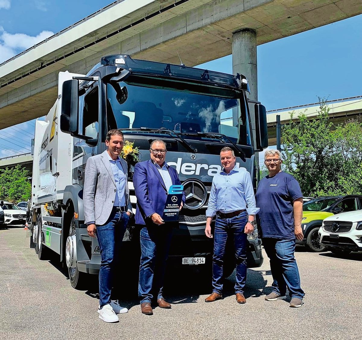 Übernahme des Mercedes-Benz eActros durch (v.l.): Nicolas Läderach, Stefan Läderach (er hält die Mercedes-Trophäe «First eMover in Switzerland» in der Hand), Thomas Hänni (Merbag) und Chauffeur Urs Aebischer, der seit 33 Jahren bei Läderach arbeitet.