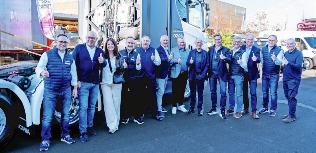 Scania-Mitarbeitende und Kunden vor dem Scania Wasserstoff-Brennstoffzellen-Lkw, der an der transport.ch erstmals der Weltöffentlichkeit präsentiert wurde.