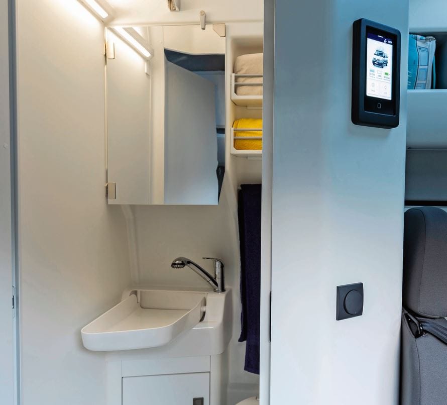 Ein Blick in die Nasszelle mit Dusche, Waschbecken und Toilette. Rechts oben die zentrale Bedieneinheit für alle Camping-Funktionen.